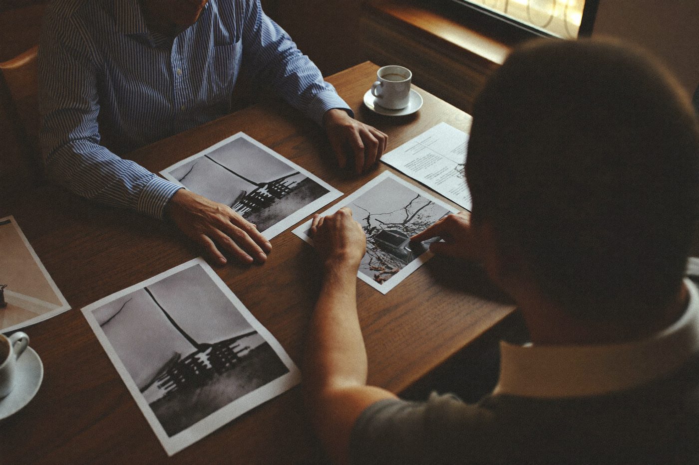 Mains de voisins autour d'une table, photos de dégâts et documents d'assurance — illustration générée
