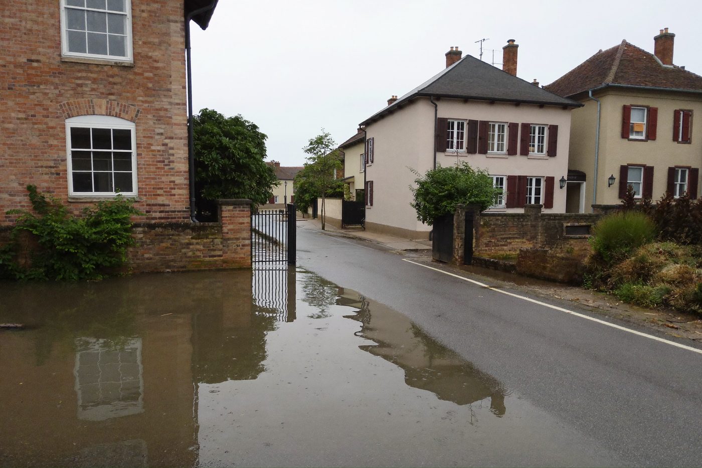 Rue pavillonnaire sous quelques centimètres d’eau calme — illustration